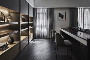 A modern office space featuring black metal and glass furniture, minimalist decor, and large windows with sheer curtains.