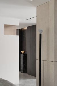 Modern interior entryway featuring concrete, marble, and wooden elements.