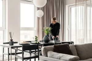 A modern living room with neutral-tones and clean lines, featuring a sofa, dining table, and minimalist decor.