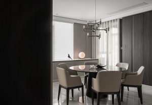 Modern kitchen with marble countertop and black seating area.