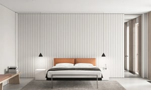 Minimalist bedroom with a orange headboard, white walls, and metallic frame bed.
