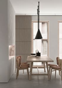 Modern dining room with minimalist design, featuring a wooden dining table, chairs, and pendant light against a concrete wall