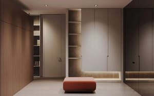 A minimalist clothing display with a red ottoman and open shelving units.