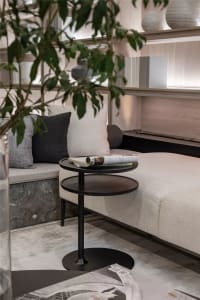 Modern living room with a white sofa, wooden side table, and marble floor