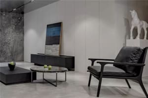 A modern interior with a minimalist design, showcasing black leather furniture on a marble floor.