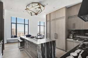 Modern minimalist kitchen featuring marble countertops and wooden cabinets.