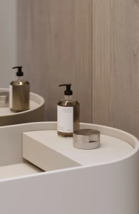A sleek, modern bathroom counter featuring minimalist ceramic accessories and simple, elegant design details.