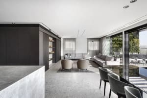 Modern living room featuring a sleek, contemporary design with concrete flooring and minimalistic furniture.