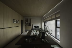 Modern residential dining area featuring a wooden table, fabric seating, and glass elements.