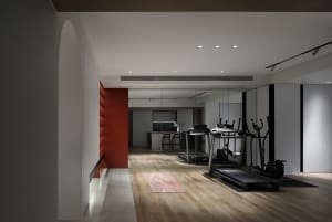 Modern home office and gym with wooden flooring and glass walls
