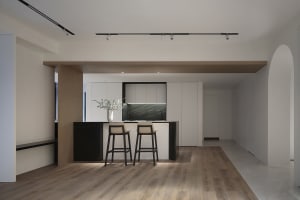 A modern residential kitchen with a concrete countertop and marble accents.