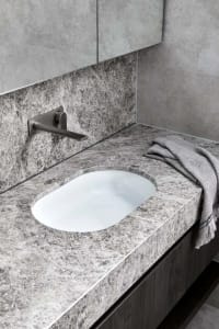 Modern bathroom featuring a grey marble countertop with a white oval sink, minimalist design.