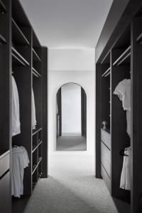 Modern closet with dark wood cabinetry and minimalist design.