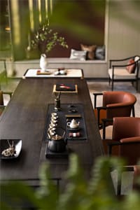 Modern living room with wooden table, leather chairs, and glass vase.