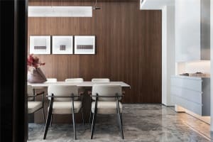 Modern dining room featuring a sleek marble table and chairs, with a wooden accent wall and white accents.
