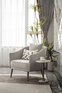 A modern fabric armchair in a contemporary living room setting, featuring minimalist design and plush seating.