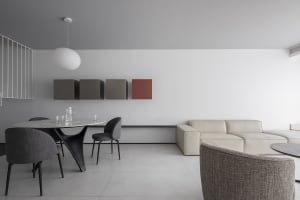 A modern living room with a minimalist design, neutral-colored furniture, and a white and black sofa.