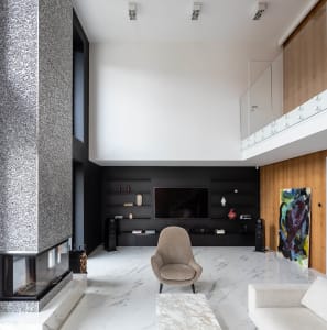 A modern living room featuring a marble floor, concrete walls, and wooden-paneled walls.