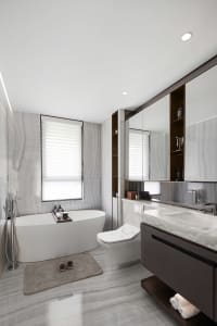 A modern bathroom featuring a freestanding tub, toilet, and vanity with a large mirror.