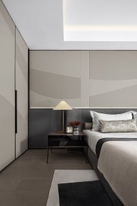 A modern bedroom with a bed, side table, lamps, and minimalist decor.