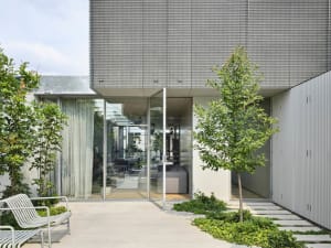 Minimalist residential architecture featuring a modern design with metal, glass, and concrete elements.