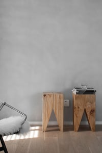 Two modern Scandinavian side tables made of light-colored wood in a living room setting.