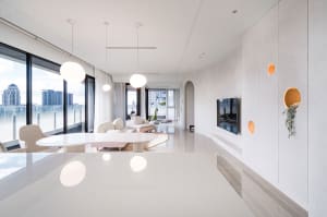 Modern living room with minimalist design, white walls, and large windows overlooking a cityscape.