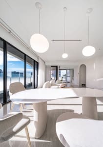 A modern living room with white furniture and minimalist design.