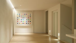 A modern interior corridor with minimalist decor featuring a colorful dot wall.