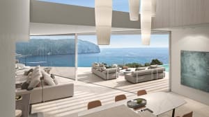 A modern living room featuring concrete walls and large glass windows overlooking the sea.