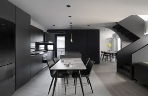 A modern black kitchen with metallic finishes.