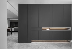 Modern minimalist home with black metallic paneling and marble flooring.