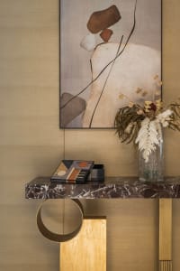 Modern entryway with marble table, dried floral arrangement, and abstract wall art