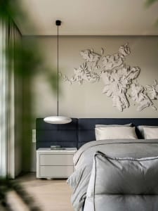 A modern minimalist bedroom featuring a fabric headboard and a wall-mounted decorative world map.