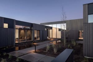 A modern house exterior featuring dark wood and glass materials.