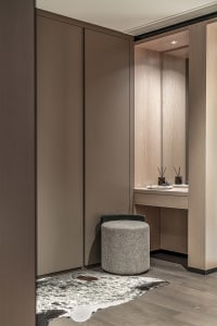 A minimalist dressing room featuring modern furnishings and a dressing table.
