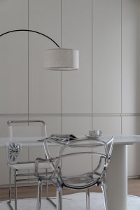 Modern minimalist kitchen featuring glass chairs and a clear glass countertop.