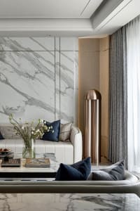 Modern living room featuring a white marble wall and floor, minimalist furniture, and contemporary decor.