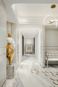 Modern minimalist corridor with marble details and abstract lighting fixture
