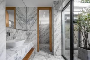 Modern minimalist bathroom with marble walls and floor.