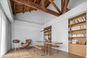 Minimalist home office featuring a wooden desk and bookshelf.