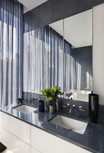 Modern bathroom with granite countertops and white sinks.