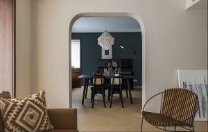 Modern dining room featuring wooden furniture and a decorative light fixture.