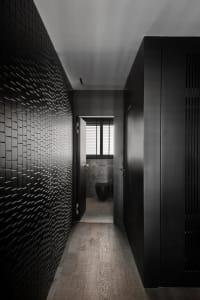 Modern bathroom with black tiled wall and wooden floor