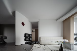 A modern living room with glass, cement, and white leather materials.