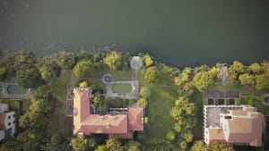 A modern residential property with a brick roof overlooking a large body of water.