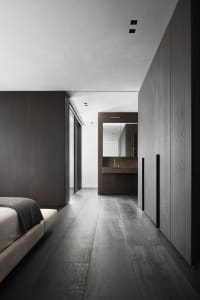Modern bedroom suite with gray wood flooring and a concrete countertop, featuring a white bed.