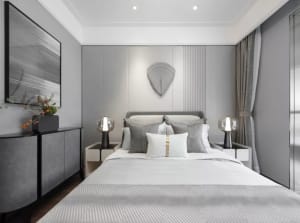 A modern bedroom featuring textured fabric bedding and walls, with minimalistic decor and a sleek, contemporary design.