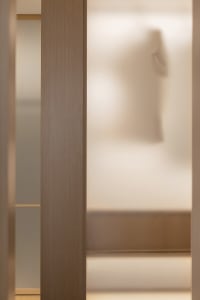 A modern closet interior with a frosted glass touch-screen door.