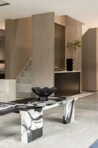 A minimalist living room featuring a marble coffee table and a modern sofa.